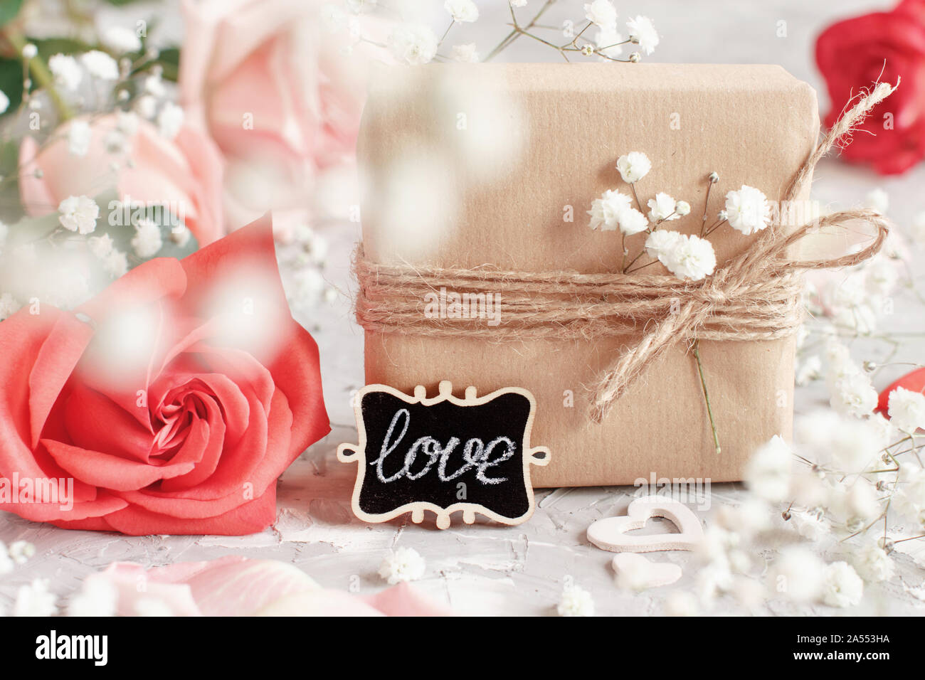 Confezioni regalo, piccola lavagna e fiori Foto Stock