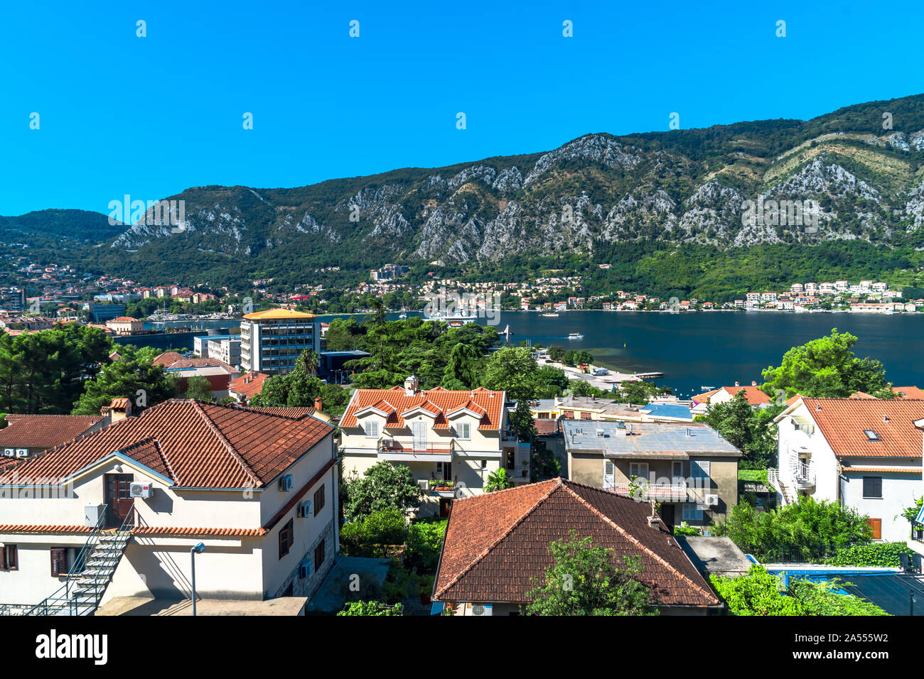 Paesaggio panoramico vista della storica città sulla Baia di Kotor, Montenegro con montagne sul cielo chiaro. Foto Stock