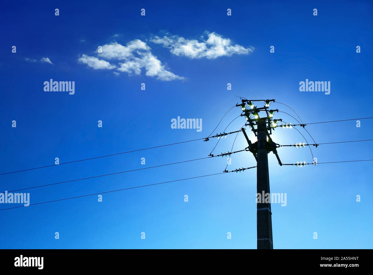 Pole e gli isolatori di linea di potenza sul cielo blu sullo sfondo. Foto Stock