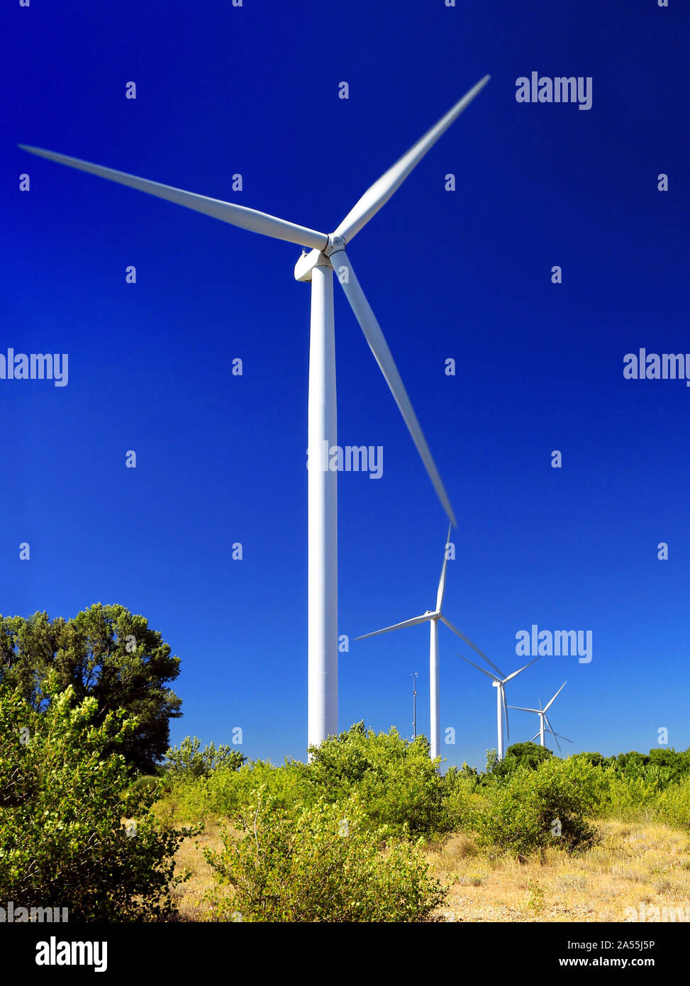 La produzione di energia pulita con turbine eoliche sul cielo blu sullo sfondo Foto Stock