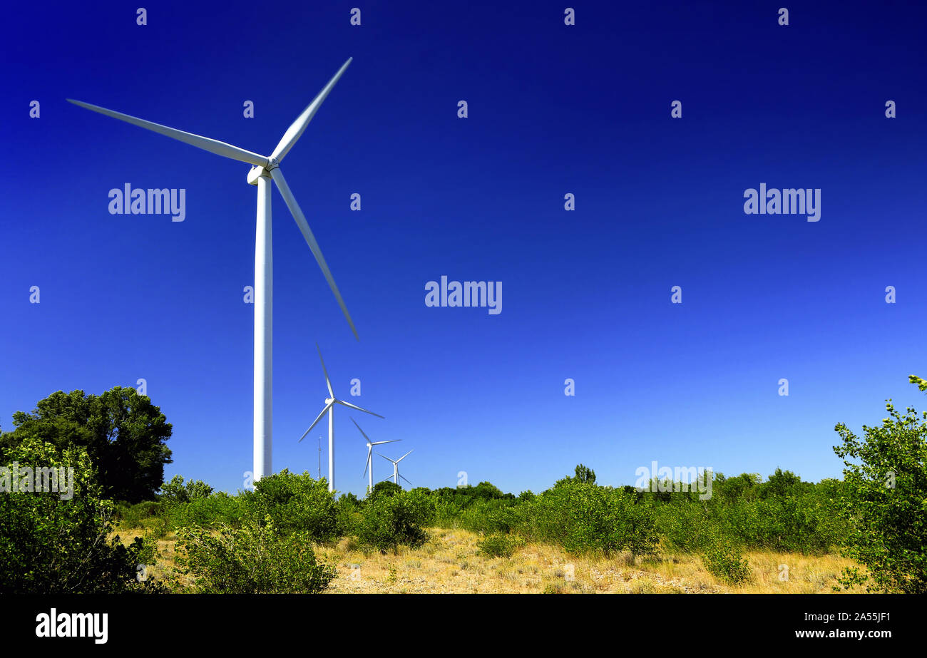 La produzione di energia pulita con turbine eoliche sul cielo blu sullo sfondo Foto Stock