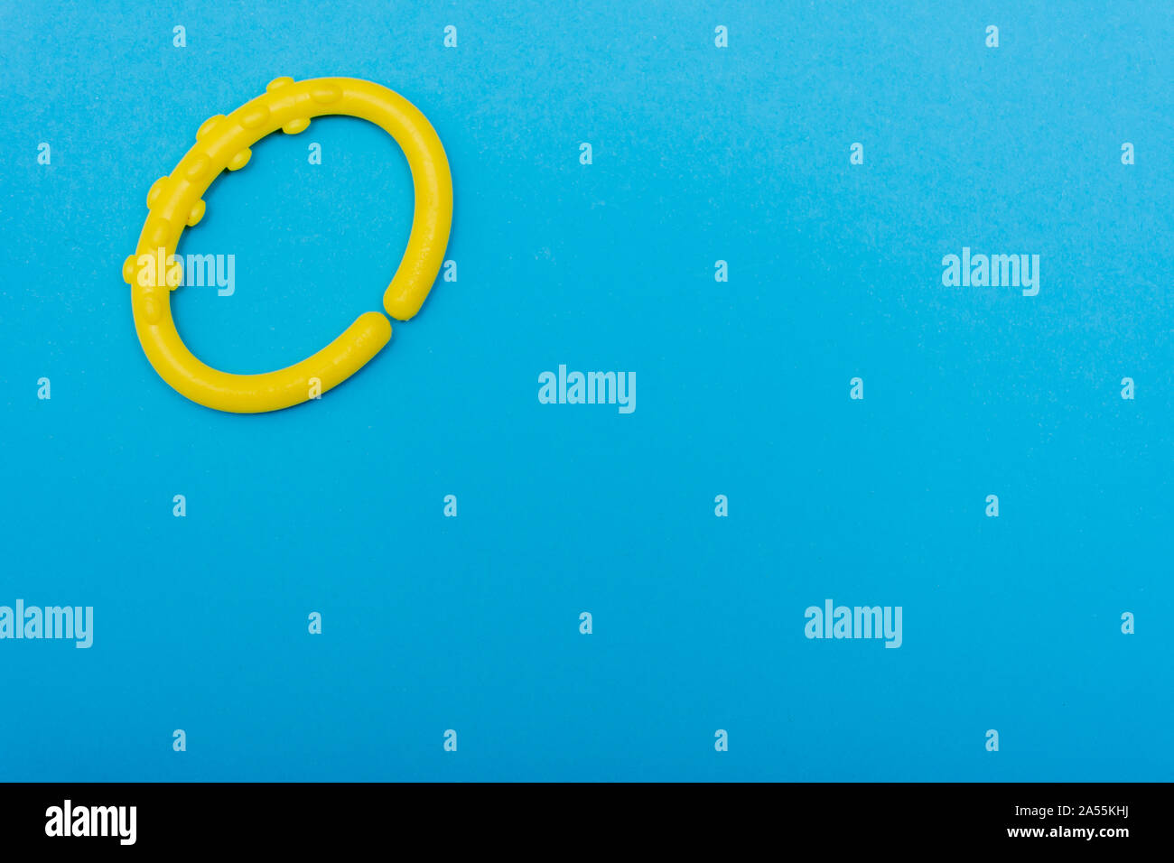 Un giallo brillante circle baby agganciare luminose aqua o sfondo blu con copia spazio per il concetto di giunzione. Foto Stock