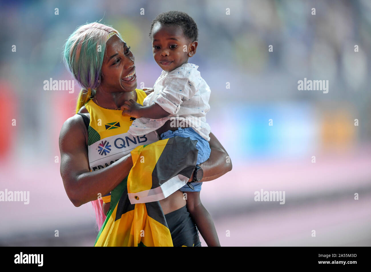 Shelly-Ann Fraser-Pryce (Giamaica) celebra la sua medaglia d'oro nella 100 metri con suo Figlio bambino. IAAF mondiale di atletica, Doha 2019 Foto Stock