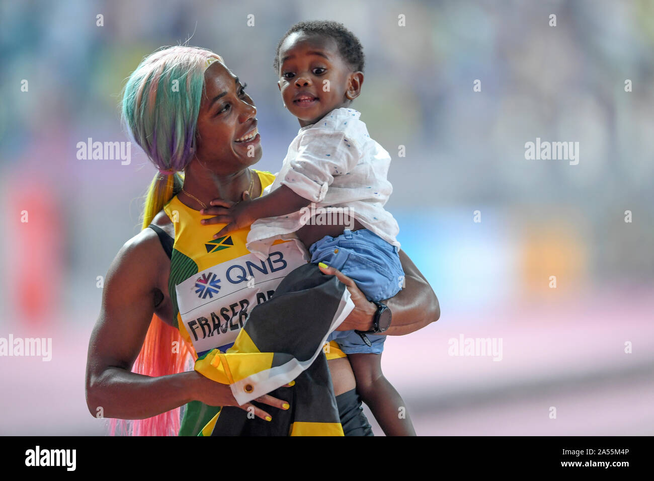 Shelly-Ann Fraser-Pryce (Giamaica) celebra la sua medaglia d'oro nella 100 metri con suo Figlio bambino. IAAF mondiale di atletica, Doha 2019 Foto Stock