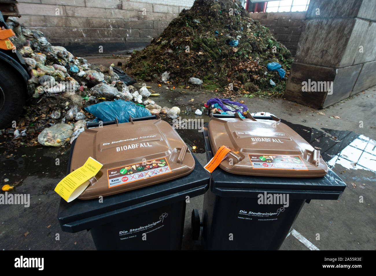 Kassel, Germania. Xviii oct, 2019. Due i rifiuti organici cassonetti a stare di fronte ad un mucchio di composto e non sottoposti a cernita dei rifiuti organici sacchi a Kassel rifiuti da impianti di energia. A partire da giugno 2018, i valori limite per le impurità in biowaste sono state serrate in modo significativo. Sacchetti di plastica, imballaggio e gli altri rifiuti residui mettono in pericolo il riciclaggio di rifiuti organici in Kassel. Credito: Swen Pförtner/dpa/Alamy Live News Foto Stock