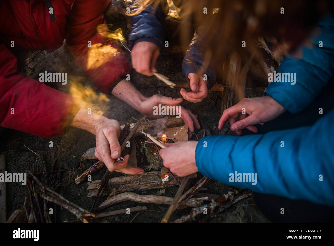 Gruppo di illuminazione di amici a un falò al crepuscolo,ritagliato, Tofino, Isola di Vancouver, Canada Foto Stock