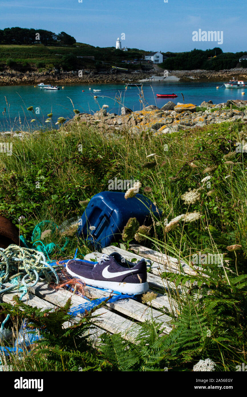 Rifiuti che sono stati raccolti insieme su Gugh, Isole di Scilly, con Sant'Agnese sullo sfondo Foto Stock