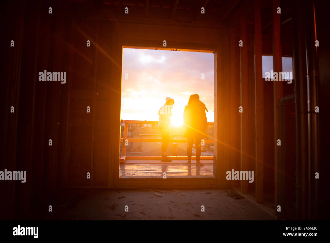 Due donne a guardare il tramonto dal balcone, vista posteriore, Vancouver, British Columbia, Canada Foto Stock