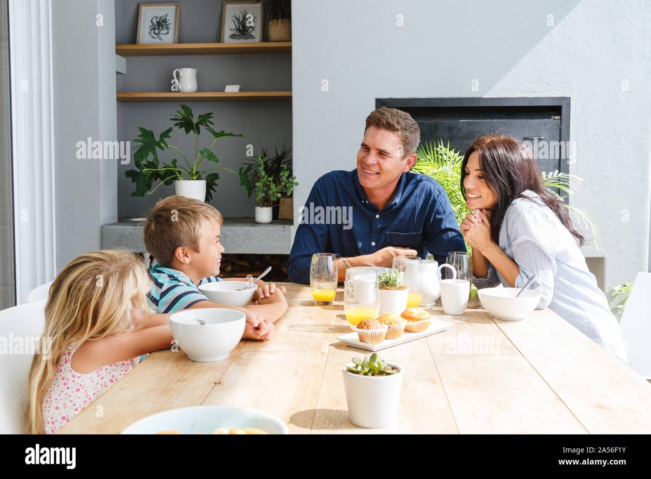 I genitori a parlare con i bambini durante il pranzo a casa Foto Stock