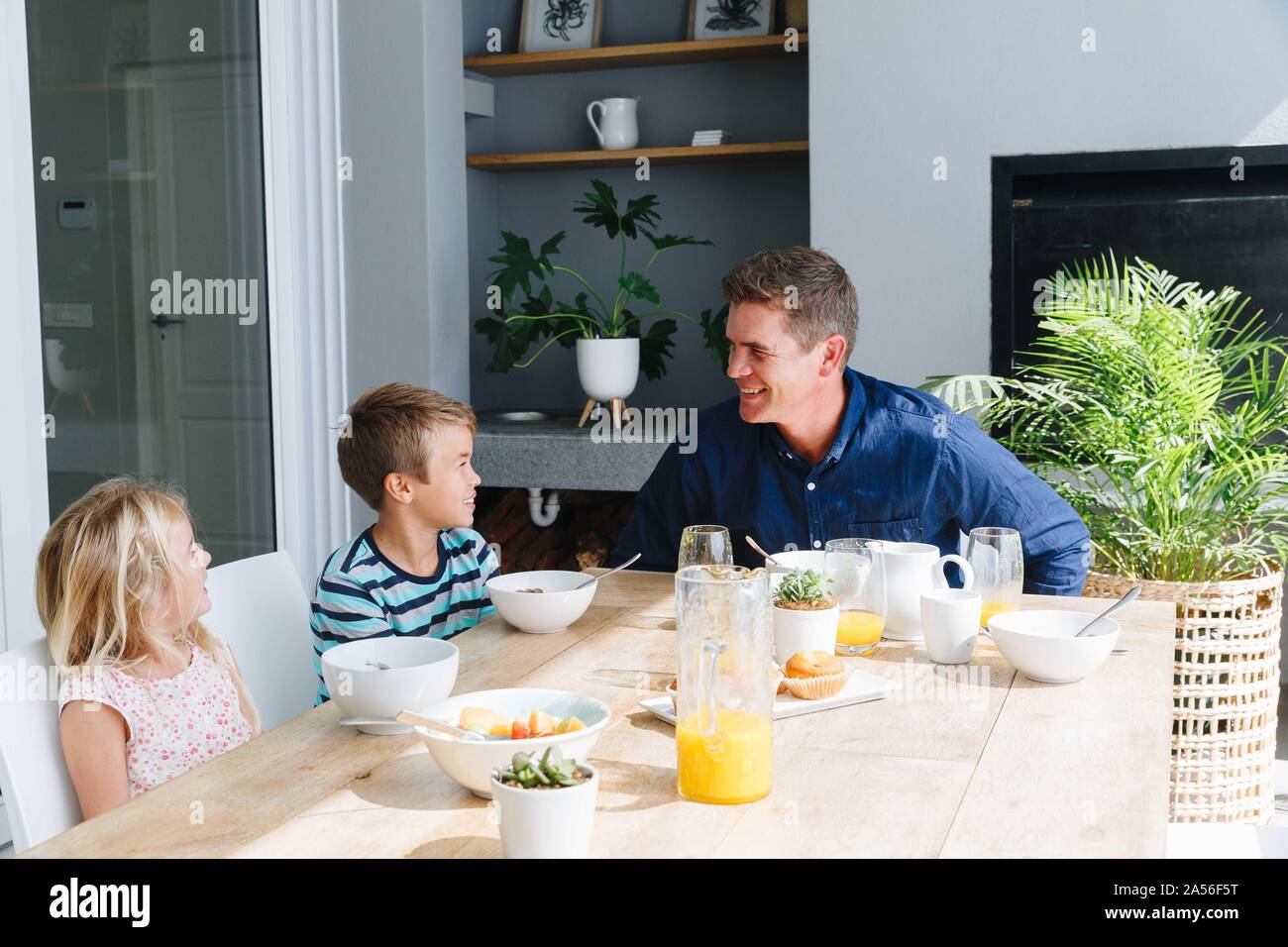 Padre di parlare con i bambini durante il pranzo a casa Foto Stock