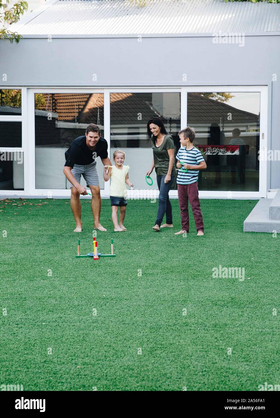 I genitori e i bambini che giocano ring toss sul prato Foto Stock