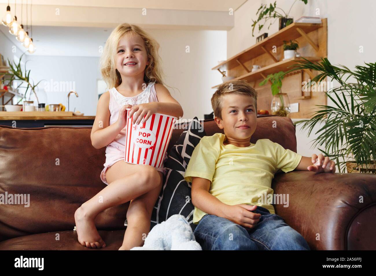 Bambini rilassante con popcorn sul divano di casa Foto Stock