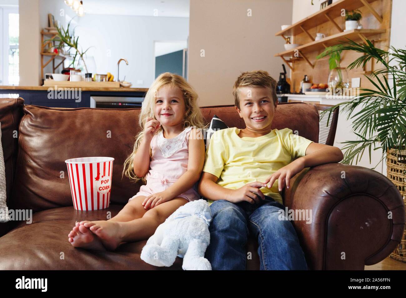 Bambini rilassante con popcorn sul divano di casa Foto Stock