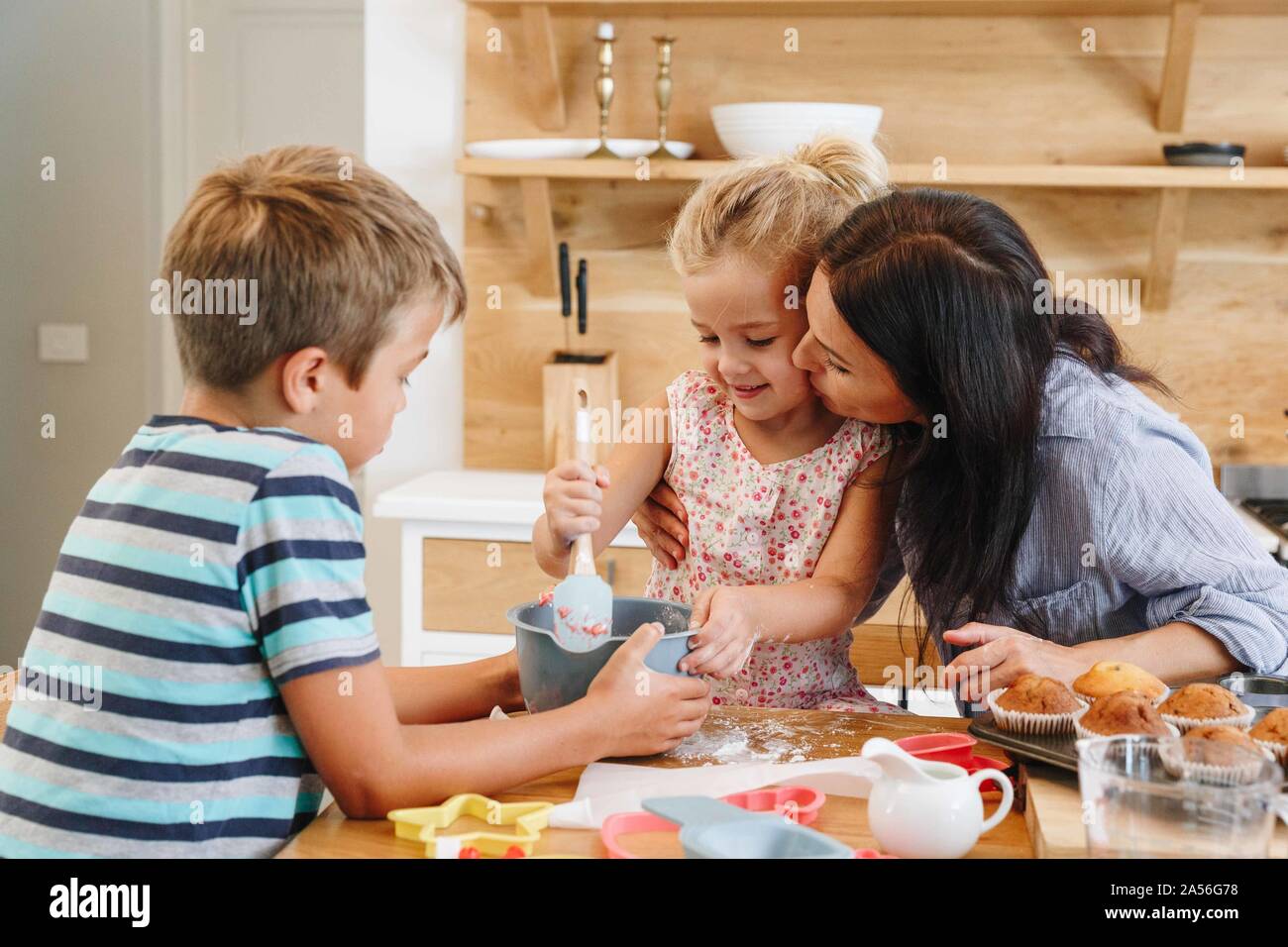 Madre e bambini tortini di cottura in cucina Foto Stock