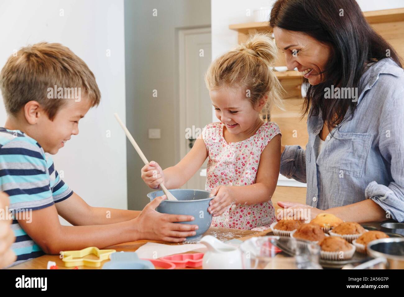 Madre e bambini tortini di cottura in cucina Foto Stock