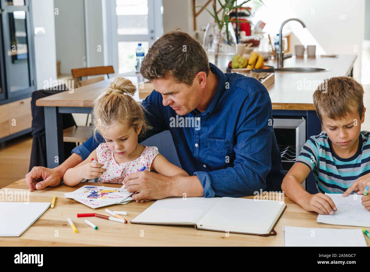 I genitori aiutano i bambini con i compiti a casa Foto Stock