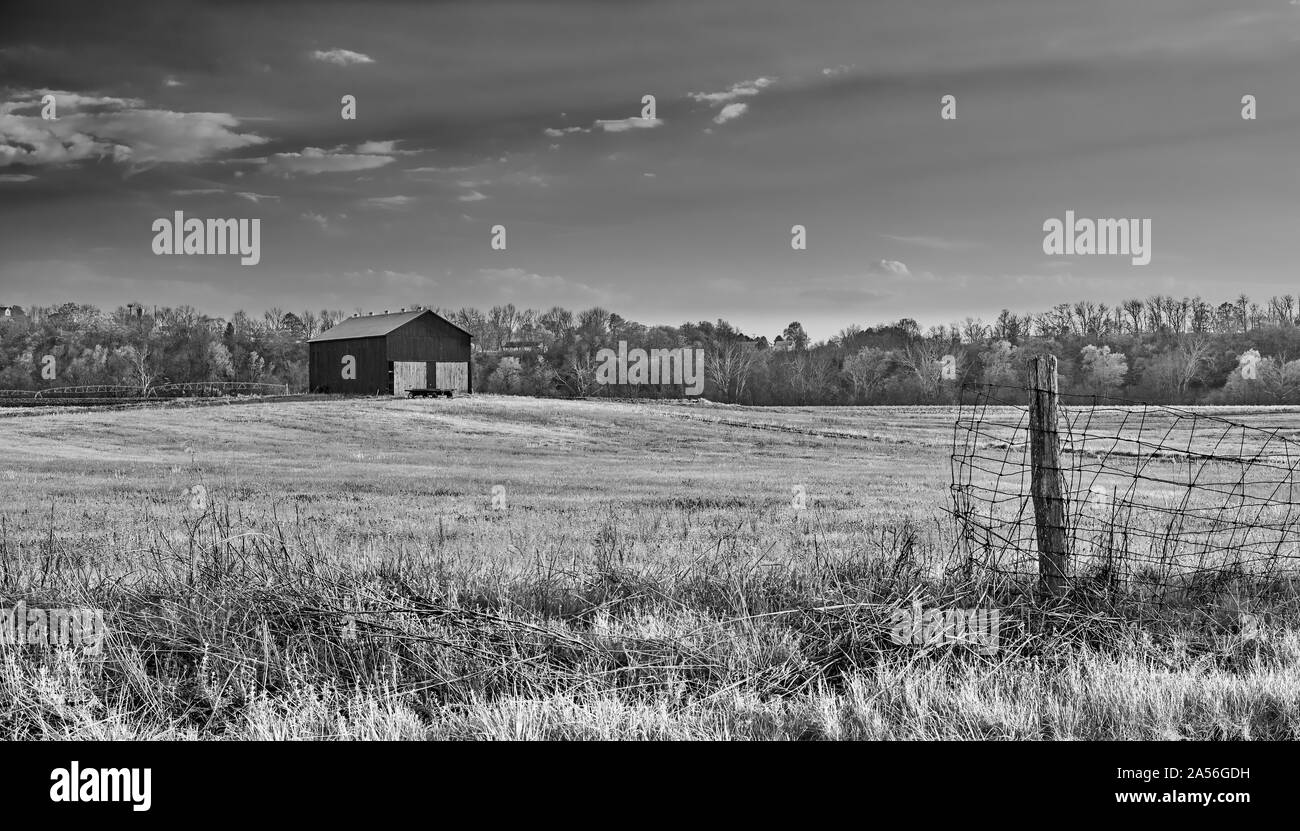 Fienile in un campo con recinto. Foto Stock