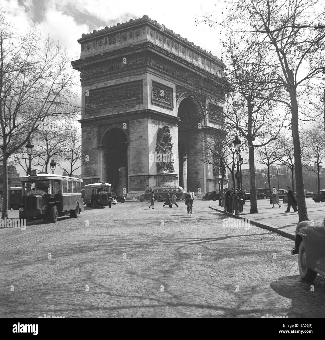 Gli autobus storici dell'epoca del 1950 sono parcheggiati in una strada acciottolata nei pressi di Place de Charles de Gaulle, sede del famoso monumento parigino, l'Arco di Trionfo, Parigi, Francia. Inaugurato nel 1836, il famoso monumento fu costruito per onorare coloro che combatterono e morirono per la Francia durante la Rivoluzione francese e le guerre napoleoniche. Foto Stock