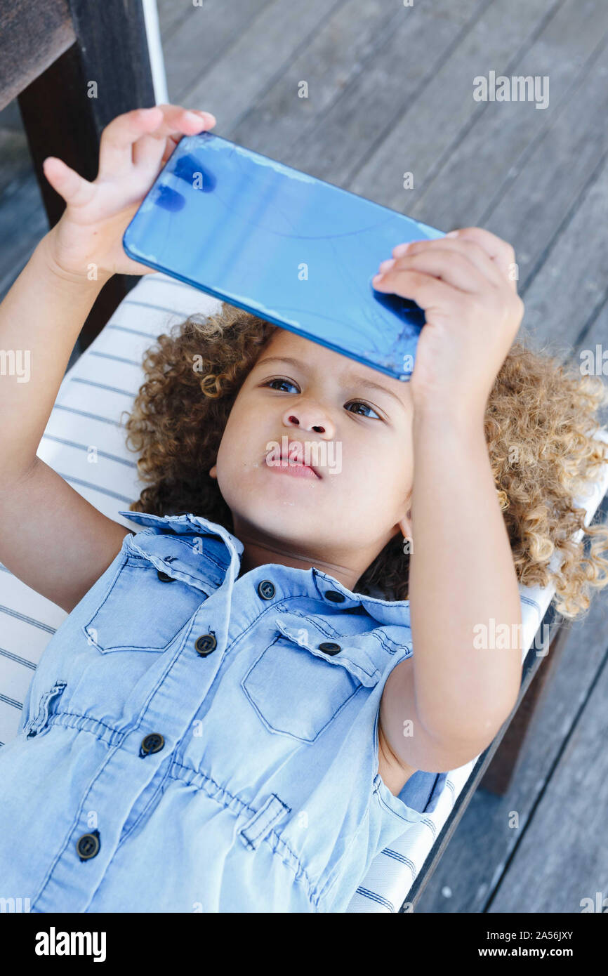 Bambina utilizza lo smartphone sul banco di lavoro Foto Stock