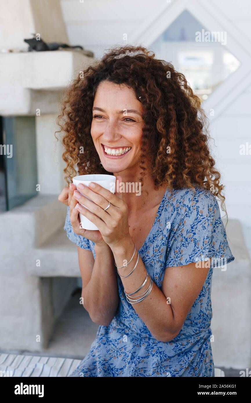 Donna gustando una bevanda calda giunte in mani a casa Foto Stock