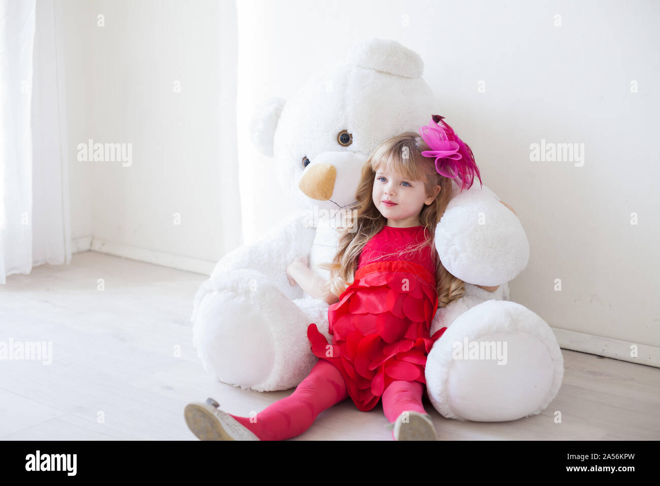 La bambina tiene un giocattolo bianco orsacchiotto Foto Stock