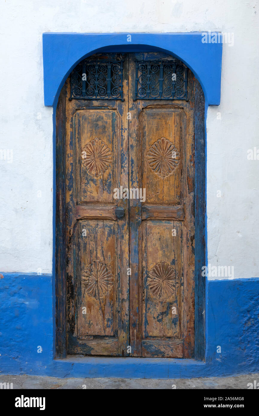 Vecchia porta di legno con decorazioni scolpite nella Medina di Asilah, Marocco Foto Stock