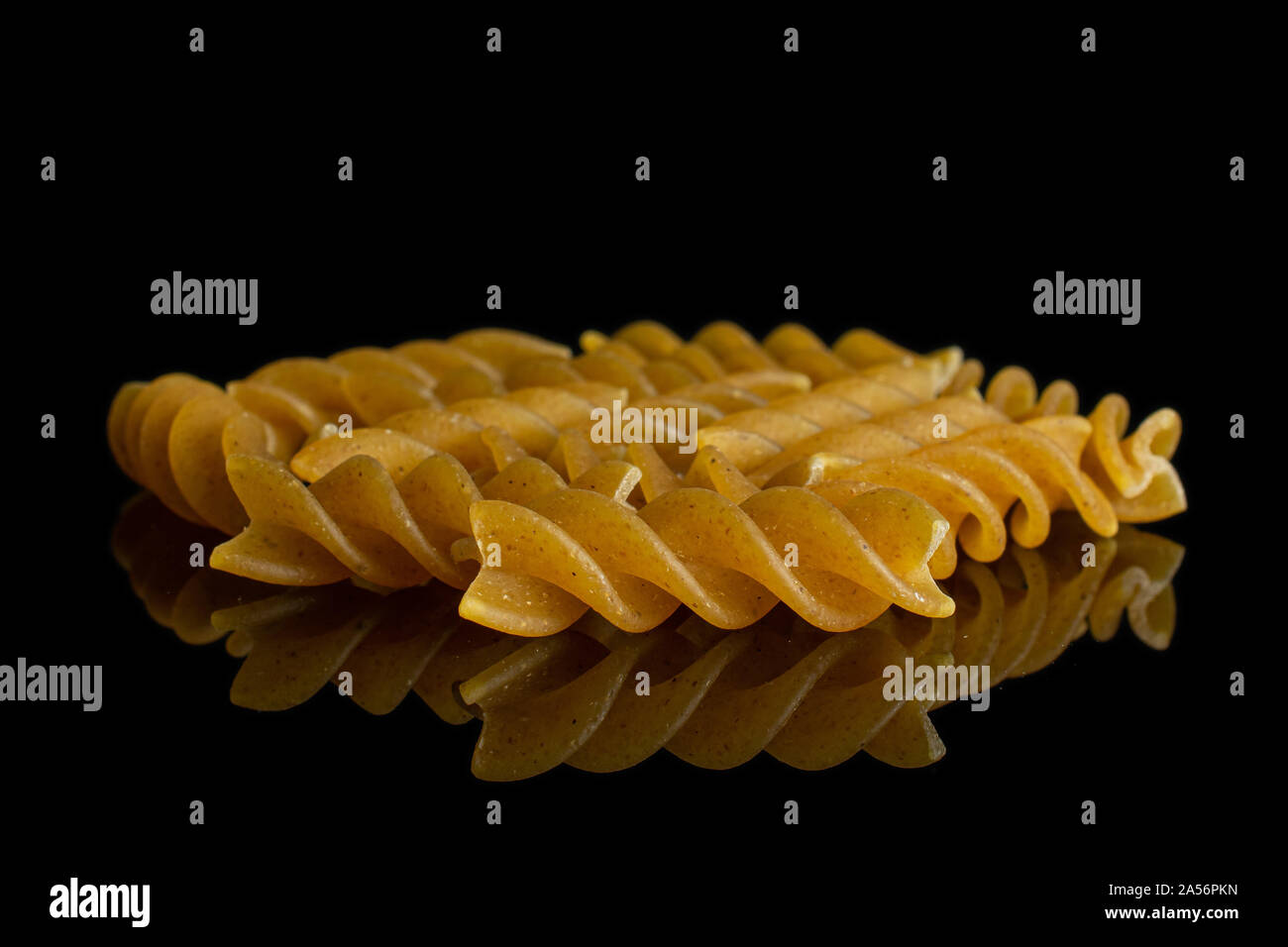Sacco di tutto il marrone e secca fusilli integrali isolato sul vetro nero Foto Stock