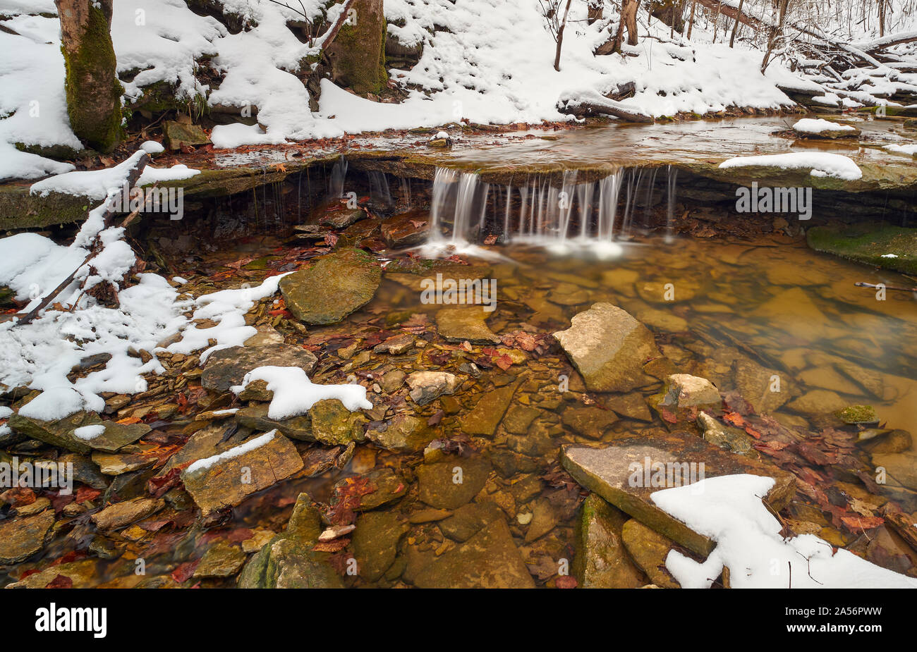 Una piccola cascata in una scena di neve. Foto Stock