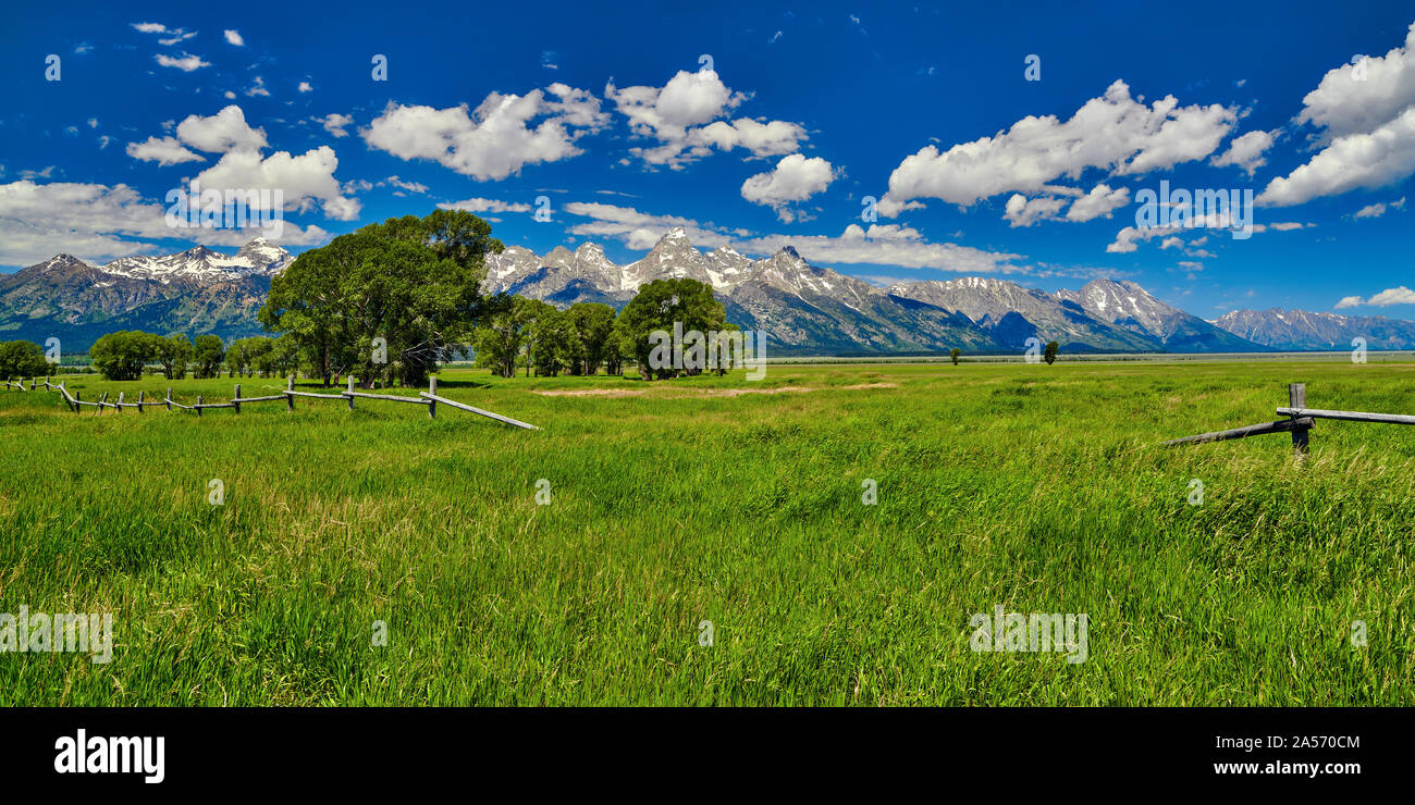 Vista del Grand Teton Mountains con campo aperto e recinzione di legno. Foto Stock