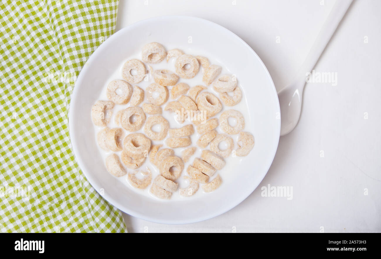 Deliziosi e nutrienti loop di cereali in una ciotola con il latte per la sana prima colazione per i bambini. Foto Stock