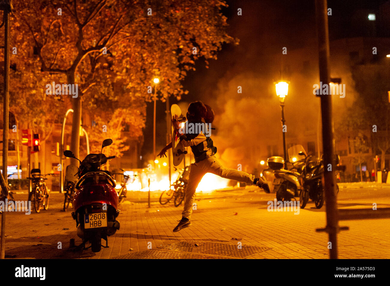 Barcellona, Spagna - 18 ottobre 2019: il giovane catalano mascherato lanciare bottiglie e pietre contro la polizia durante scontri per la Catalogna indipendenza di notte provocando r Foto Stock