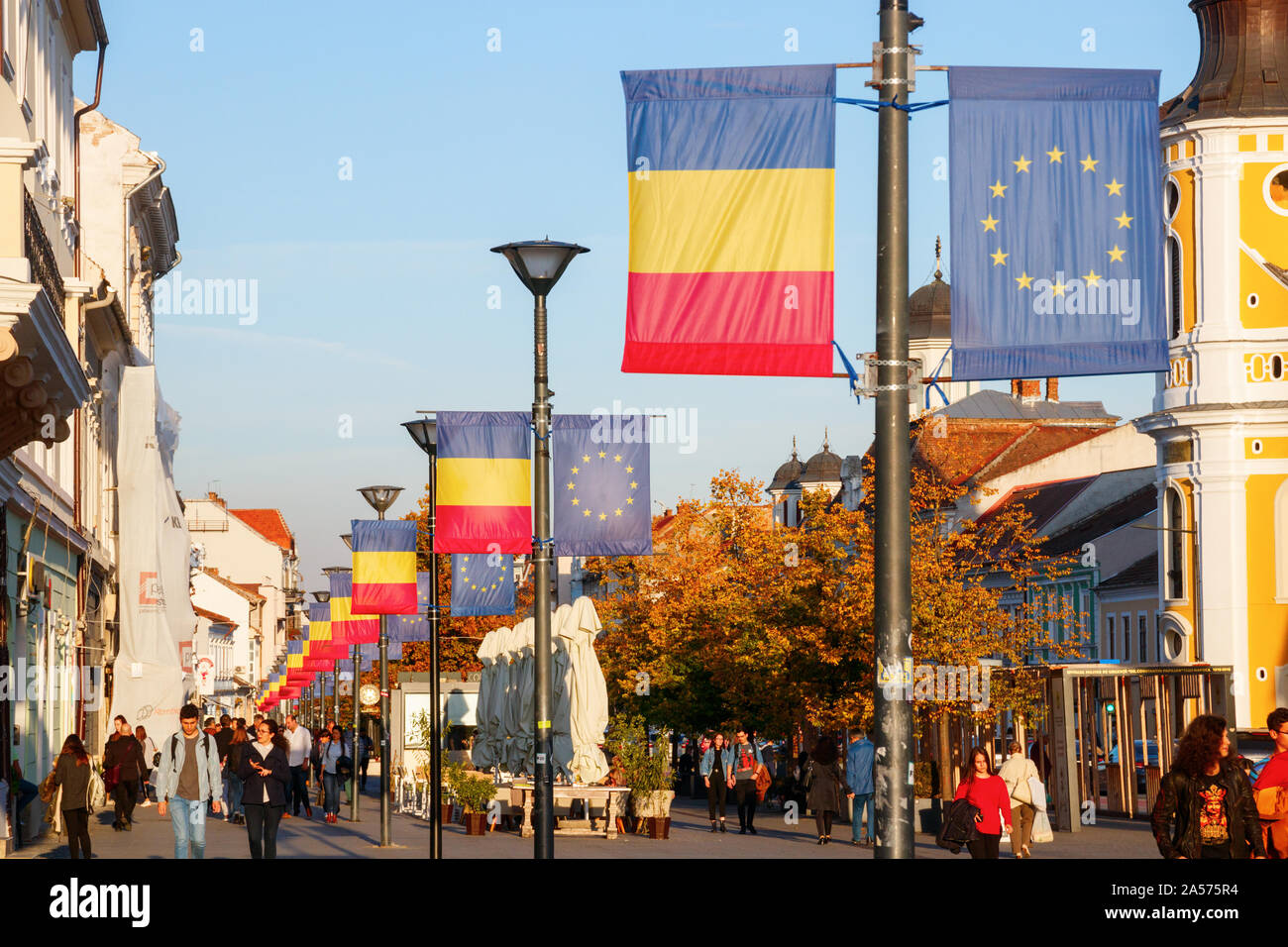 Linea di lanterne di strada con le bandiere della Unione europea e la Repubblica di Romania presso la Avenue Eroilor. Cluj-Napoca, Romania Foto Stock