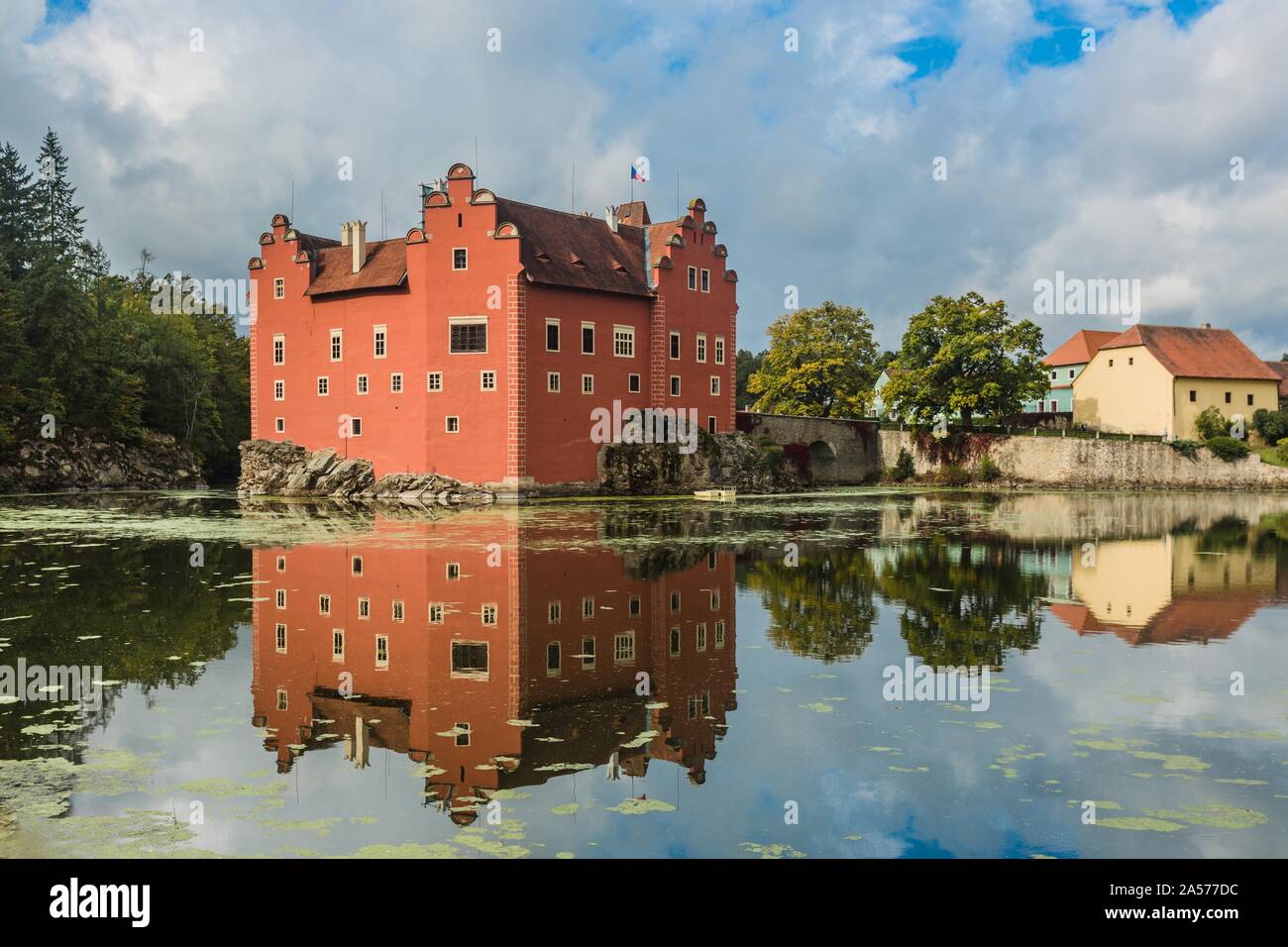 Cervena Lhota, Repubblica Ceca - 28 Settembre 2019: vista del famoso castello rosso in piedi su una roccia al centro di un lago. Giornata di sole e cielo blu. Foto Stock