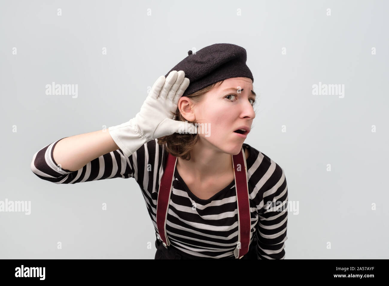 Giovani caucasici donna mime facendo un gesto dell'udito Foto Stock