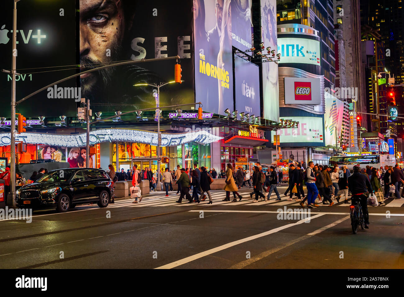 Persone attraversano 42nd street passando la pubblicità per Apple TV+ servizio di streaming, dotate di un annuncio per il "Morning Show" con Jennifer Anniston, tra altri programmi, in Times Square a New York martedì, 15 ottobre 2019. Il nuovo servizio debutterà il 1 novembre presso il tasso di affare di $4.99 al mese. (© Richard B. Levine) Foto Stock