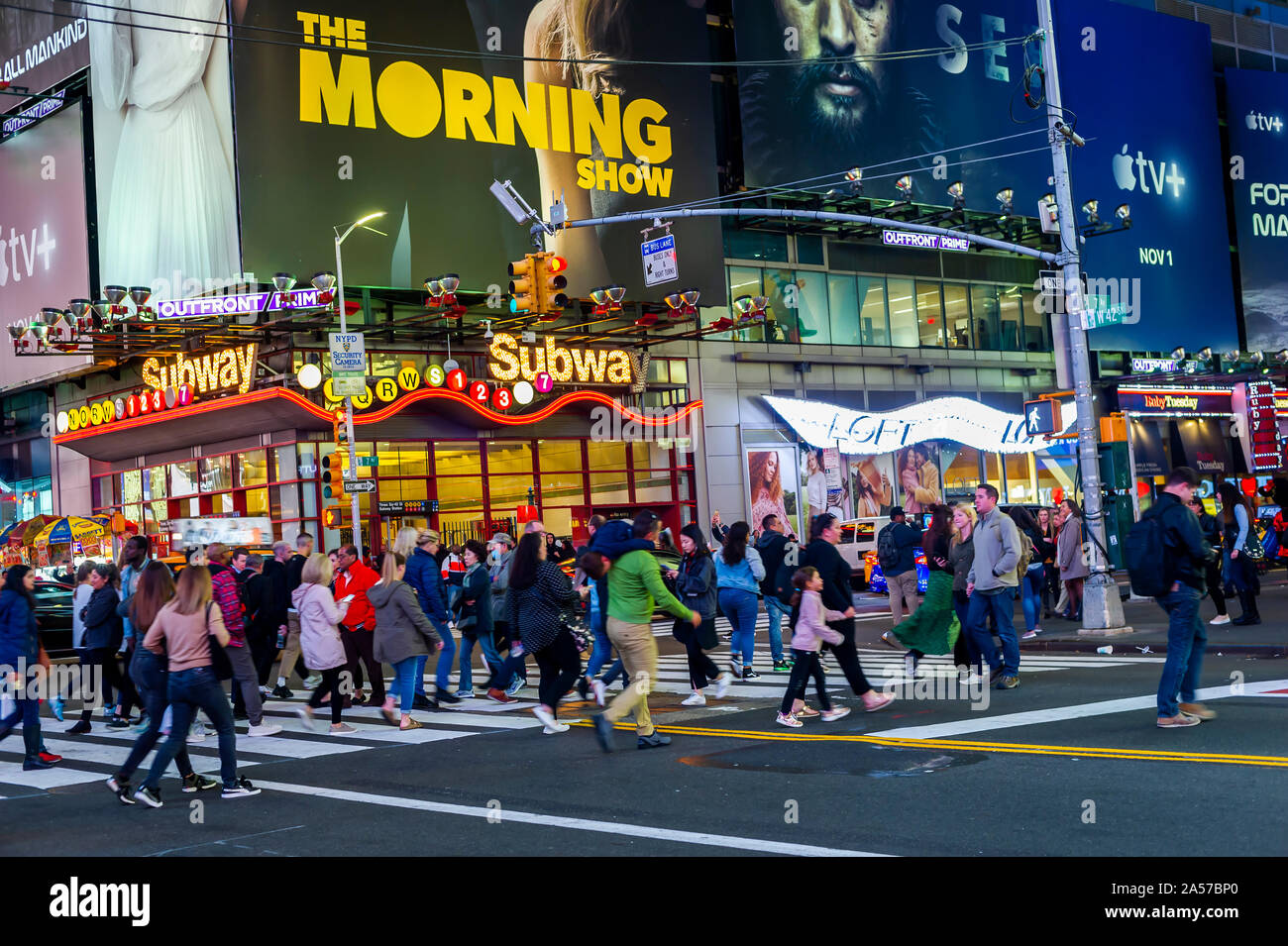 Persone attraversano 42nd street passando la pubblicità per Apple TV+ servizio di streaming, dotate di un annuncio per il "Morning Show" con Jennifer Anniston, tra altri programmi, in Times Square a New York martedì, 15 ottobre 2019. Il nuovo servizio debutterà il 1 novembre presso il tasso di affare di $4.99 al mese. (© Richard B. Levine) Foto Stock