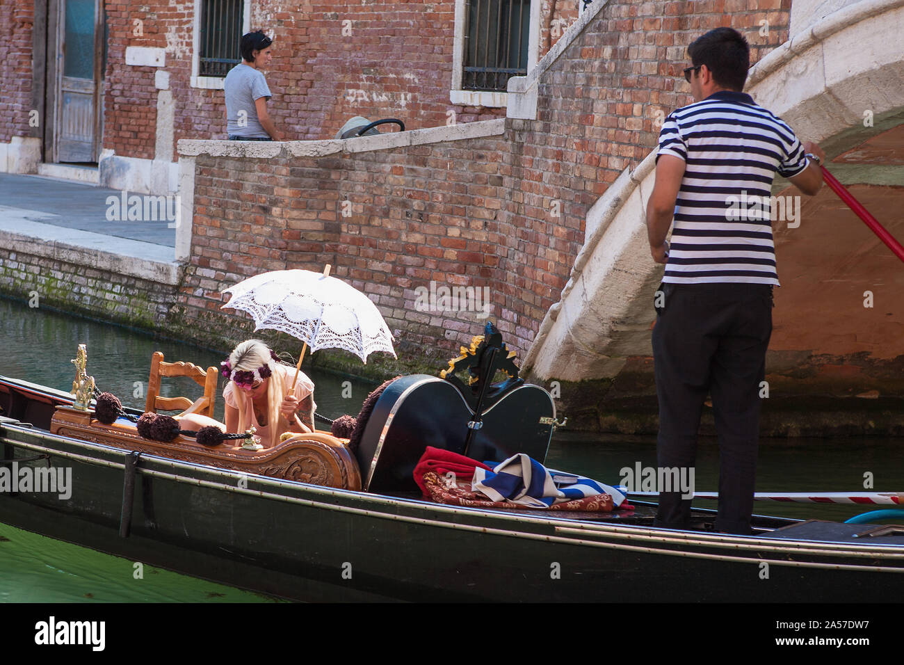 Gondola con glamour del biondino di passeggero in possesso di un ombrellone, Rio del Malcanton, Santa Croce, Venezia, Italia Foto Stock