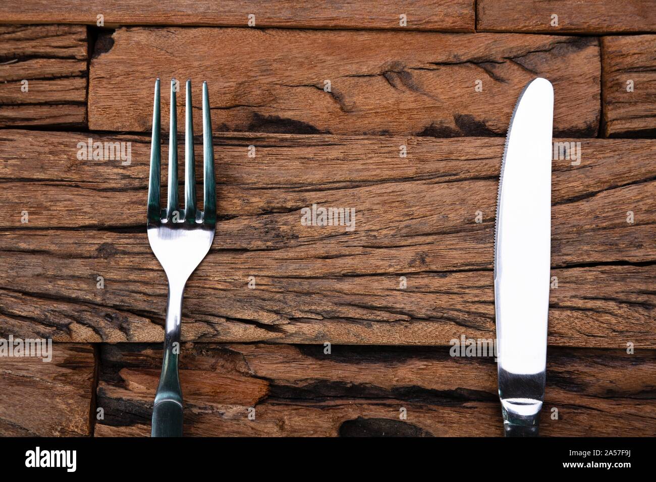 Lo spazio vuoto tra la forcella e il coltello sul tavolo di legno Foto Stock Lo spazio vuoto tra la forcella e il coltello sul tavolo di legno Foto Stock