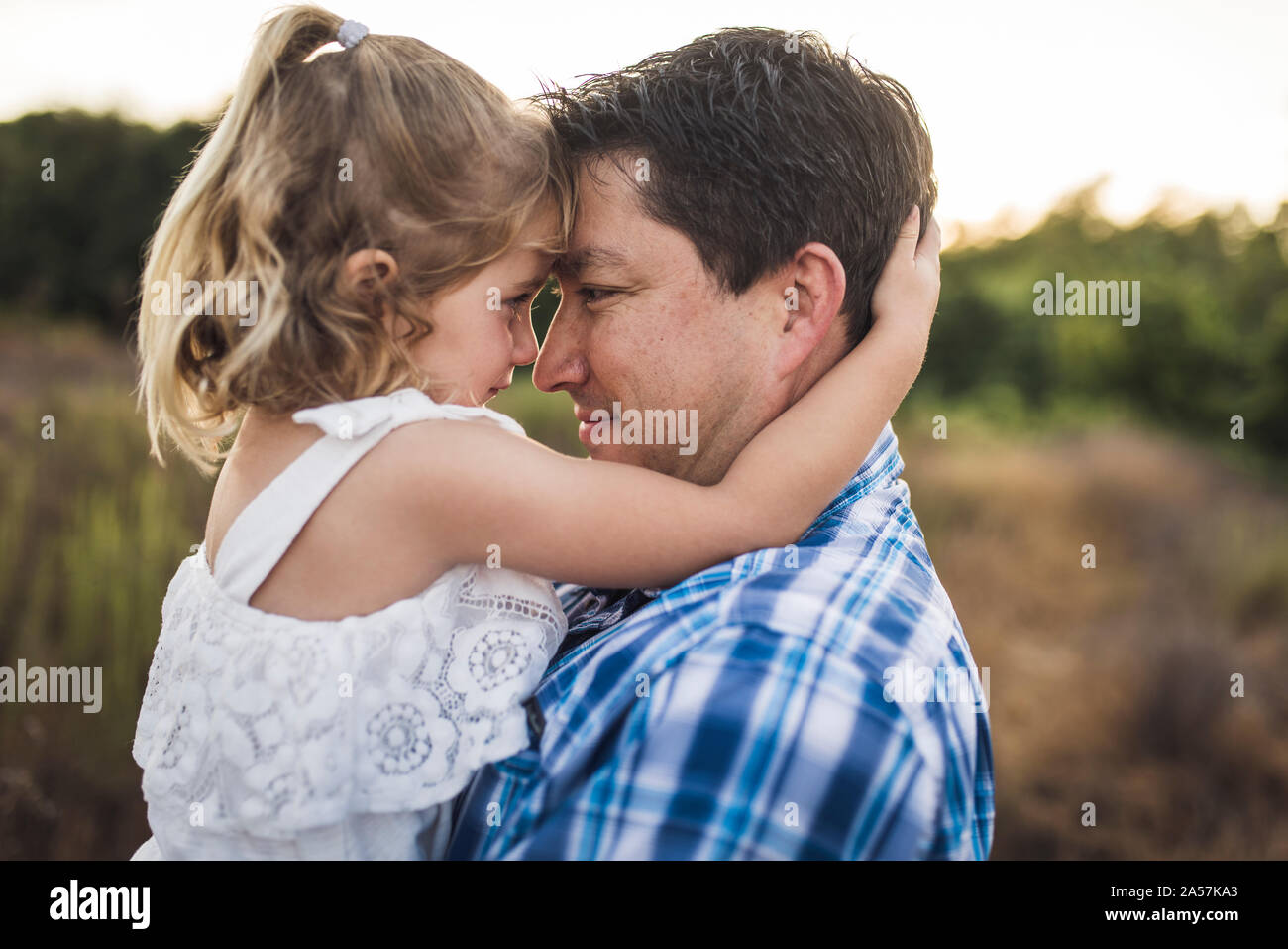 Ragazza giovane cercando di papà gli occhi mentre si tocca fronte Foto Stock
