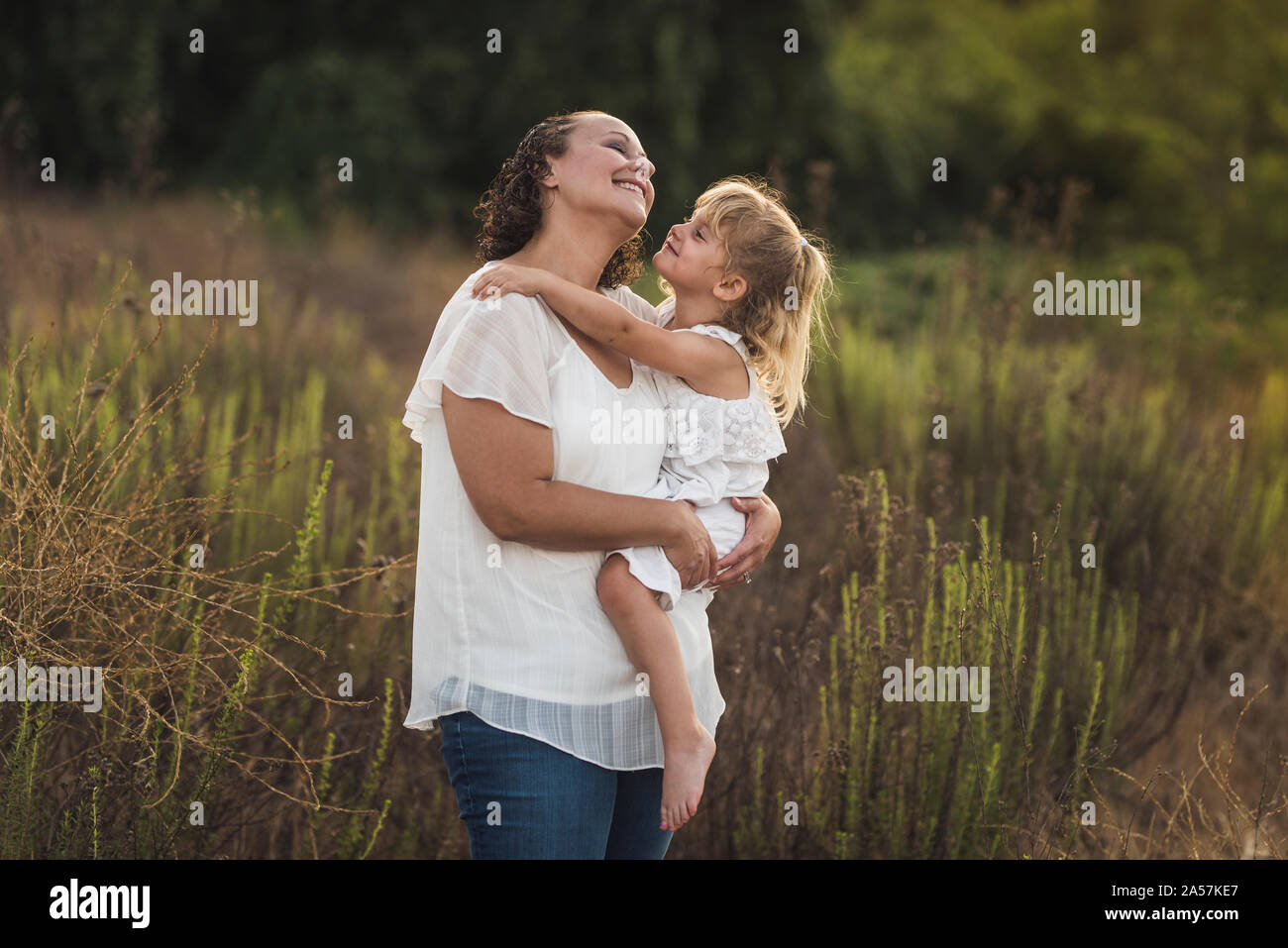 Gioiosa di ridere mom sollevamento fino a piedi nudi 4 anni figlia - B/W photo Foto Stock