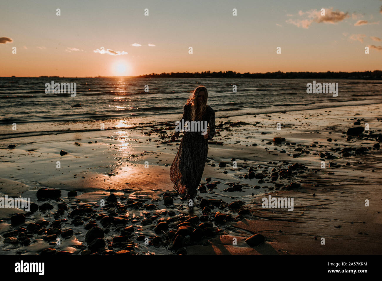 La donna in un abito su una spiaggia Foto Stock