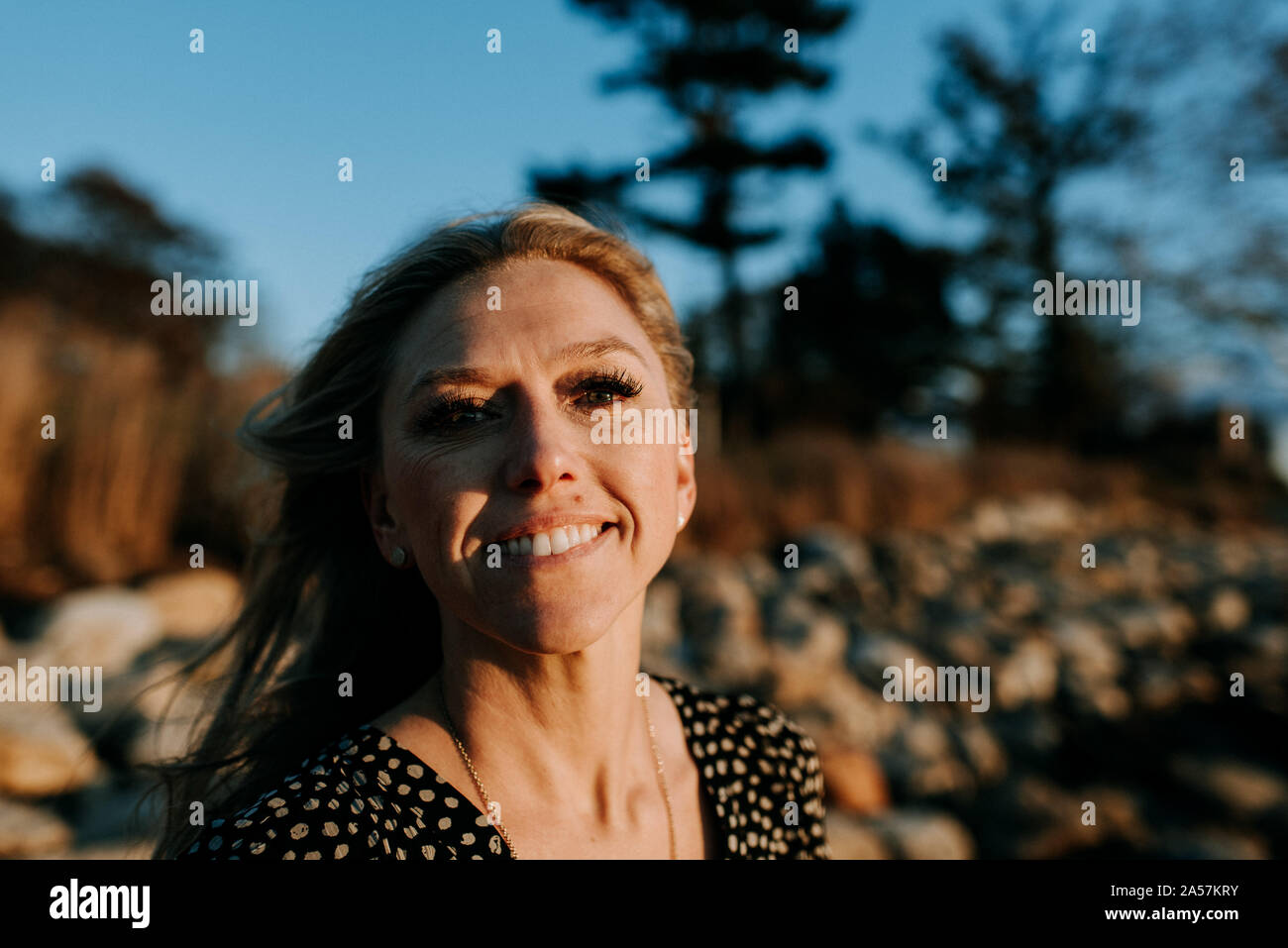 Ritratto di donna felice all'esterno guardando la telecamera Foto Stock