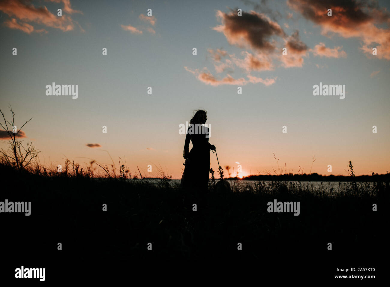 Donna sulla spiaggia al tramonto Foto Stock
