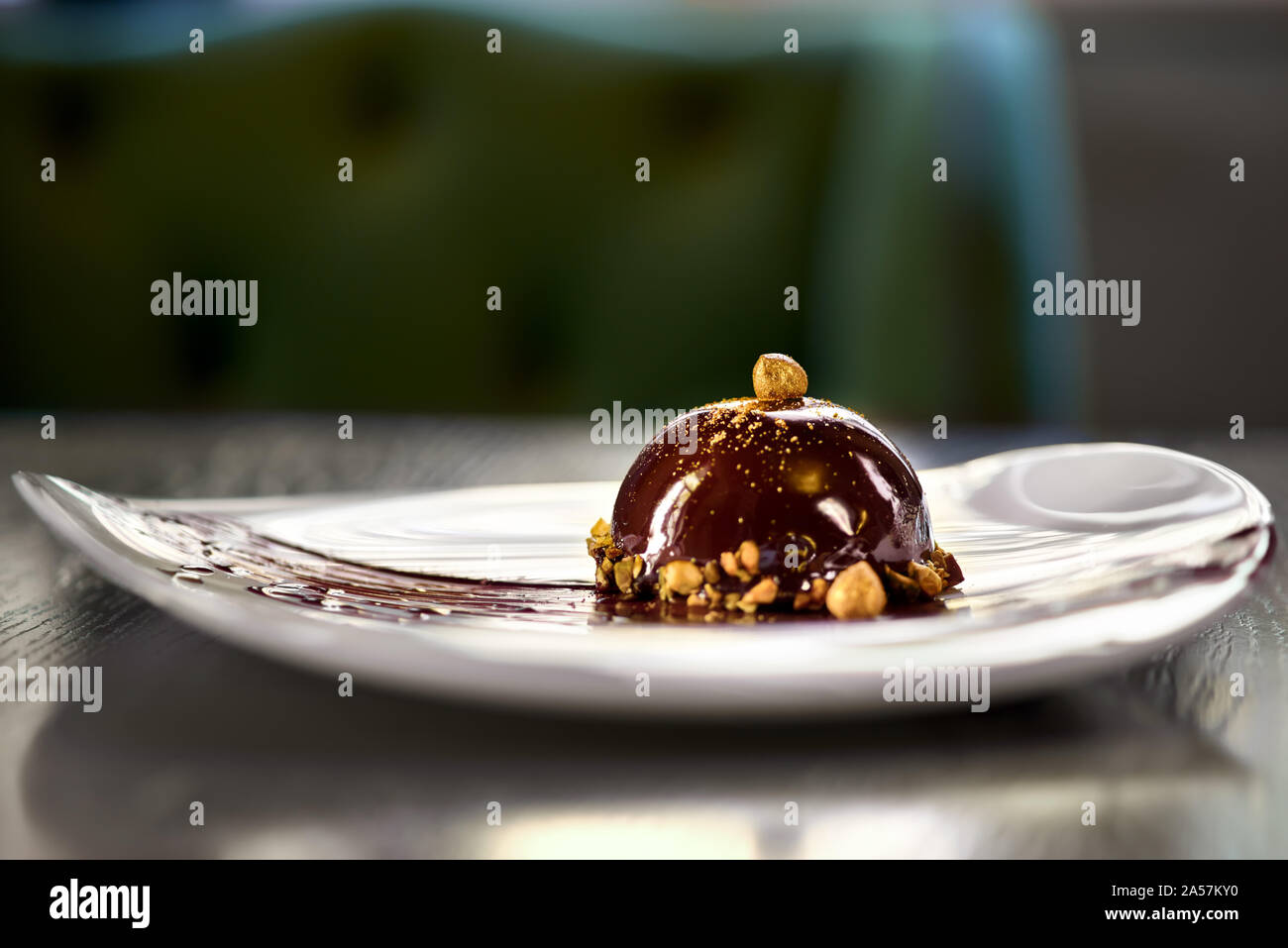 Francese mousse mini dessert di pasticceria in glassa di cioccolato su una piastra. Il dessert in tavola in un ristorante. Close up Foto Stock