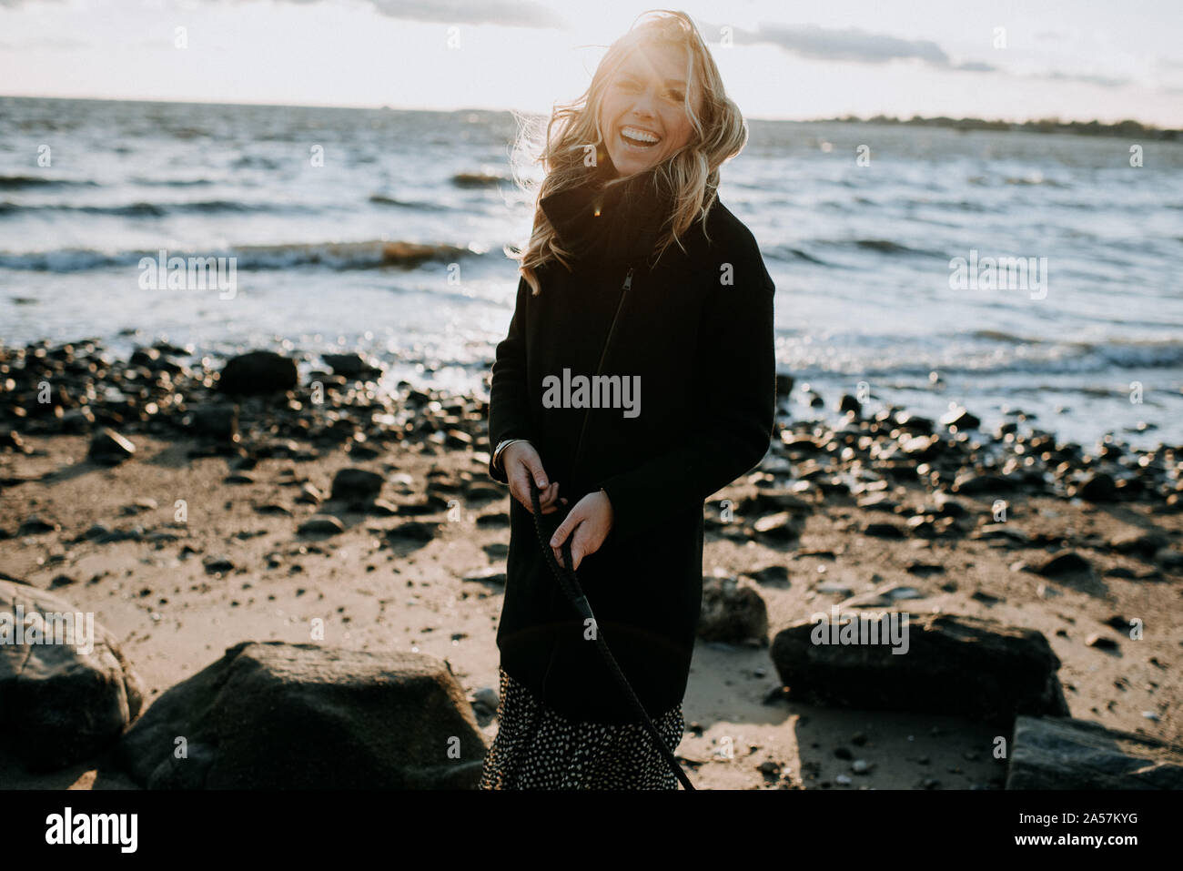 Ritratto di una donna che ride sulla spiaggia in inverno Foto Stock