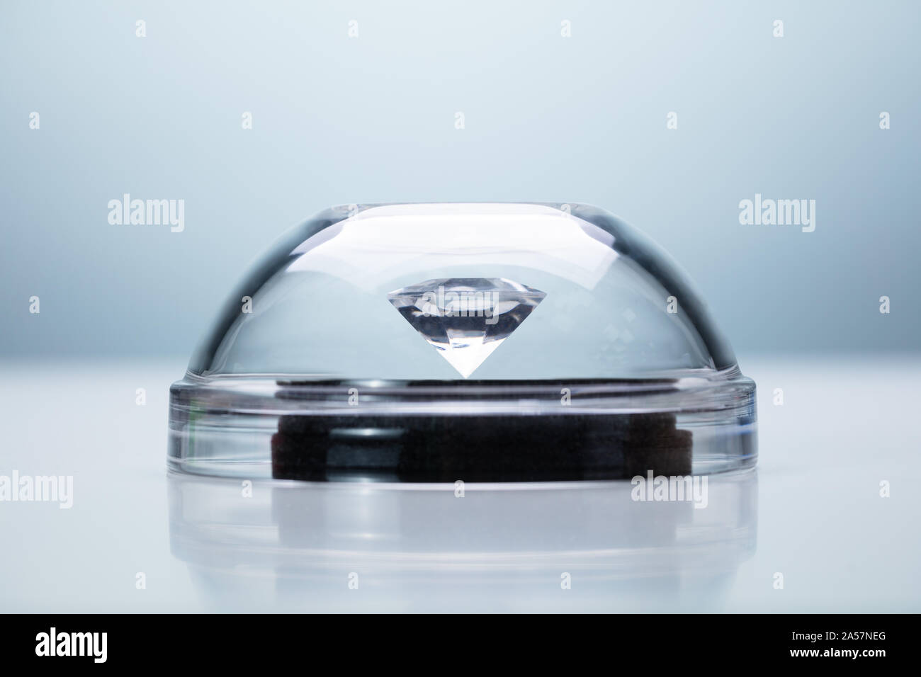 Diamond protetto con cupola trasparente su sfondo grigio Foto Stock