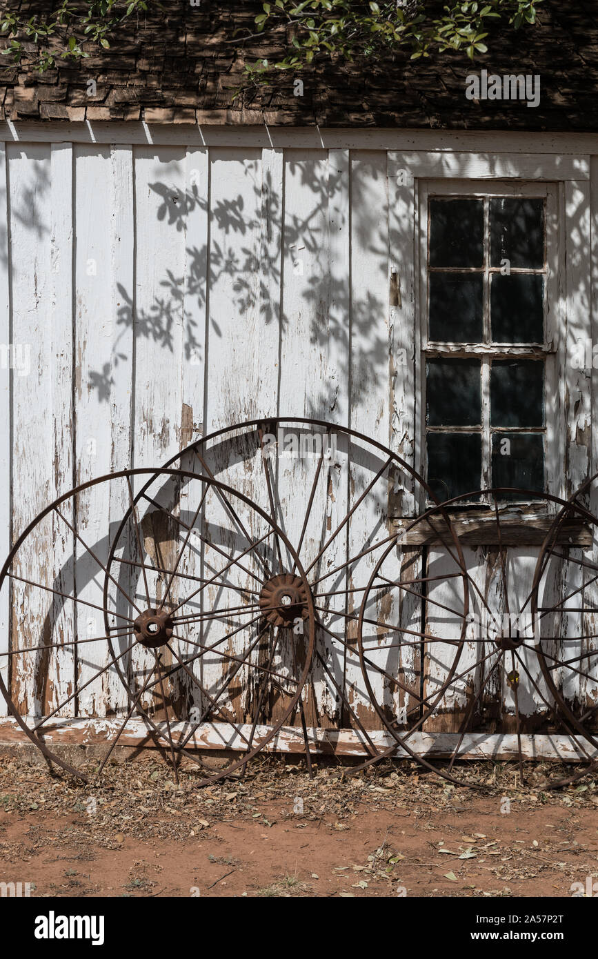 Ruote di carri contro un edificio a Buffalo Gap storico villaggio di Taylor non costituite in società County, Texas, città con lo stesso nome, nei pressi di Abilene Foto Stock