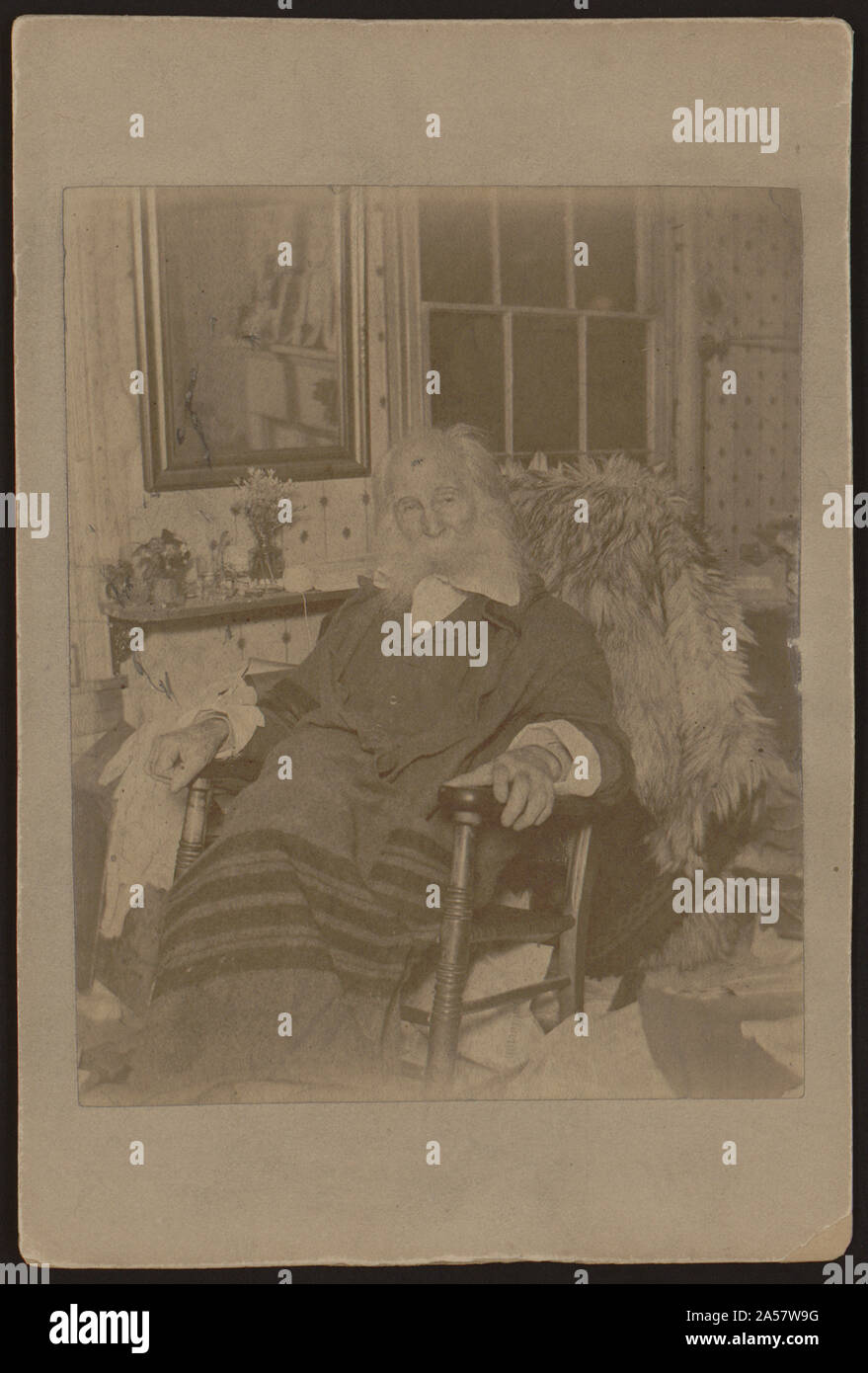 Walt Whitman, come un uomo anziano, ritratto a figura intera, seduto nella sedia a dondolo, rivolto verso la parte anteriore Foto Stock