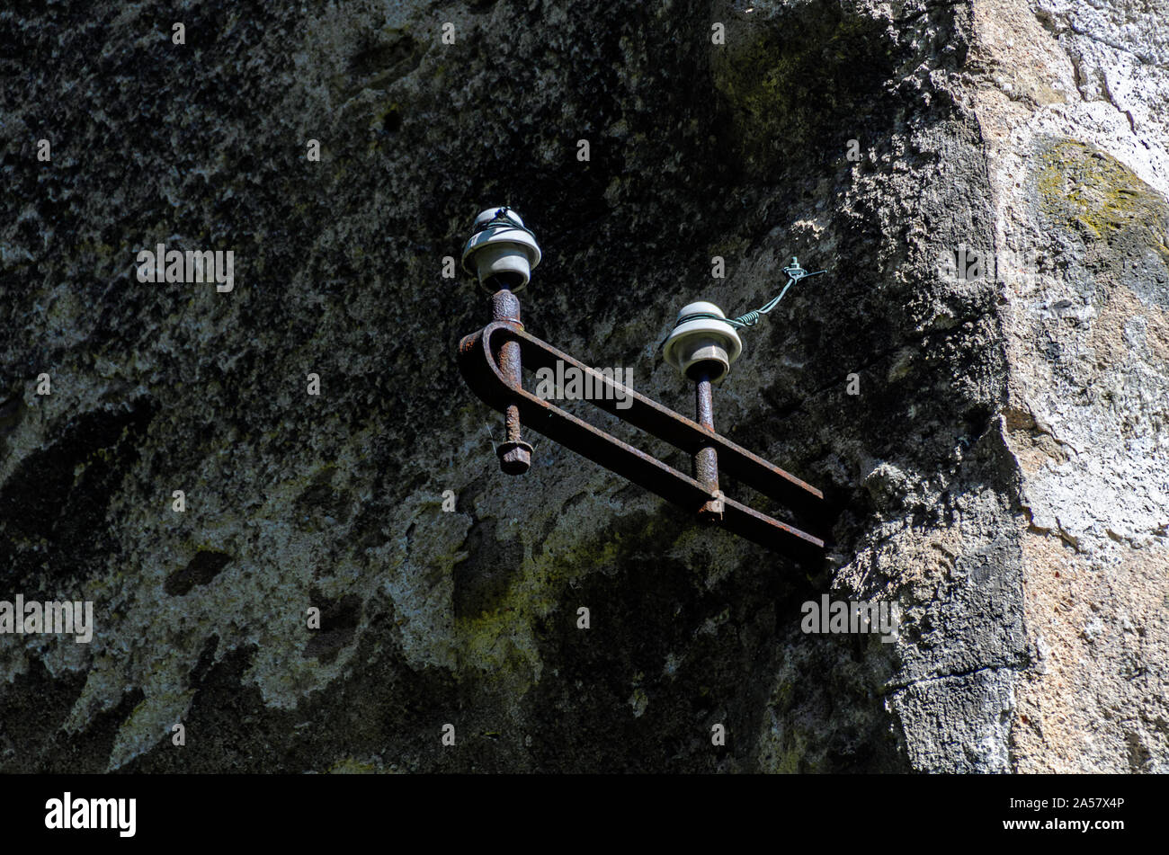 Vecchio isolatori elettrici in corrispondenza di una parete di desolata Foto Stock
