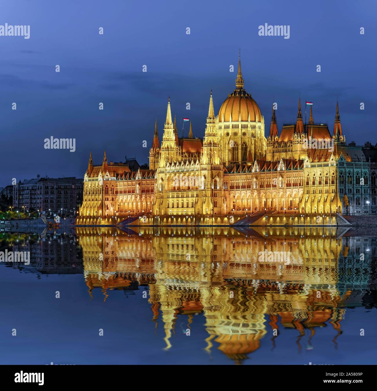 Il Parlamento europeo con la riflessione nel Danubio, illuminato, crepuscolo, Budapest, Ungheria Foto Stock
